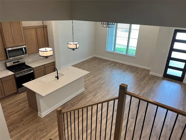 a view of a kitchen with a sink wooden floor and windows