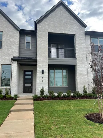 a front view of a house with a yard and trees