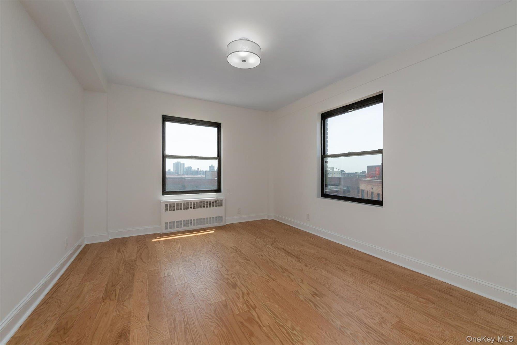 99-52 66th Road, Unit W7 Queens, NY 11374 - Photo 12 of 22 an empty room with wooden floor and windows