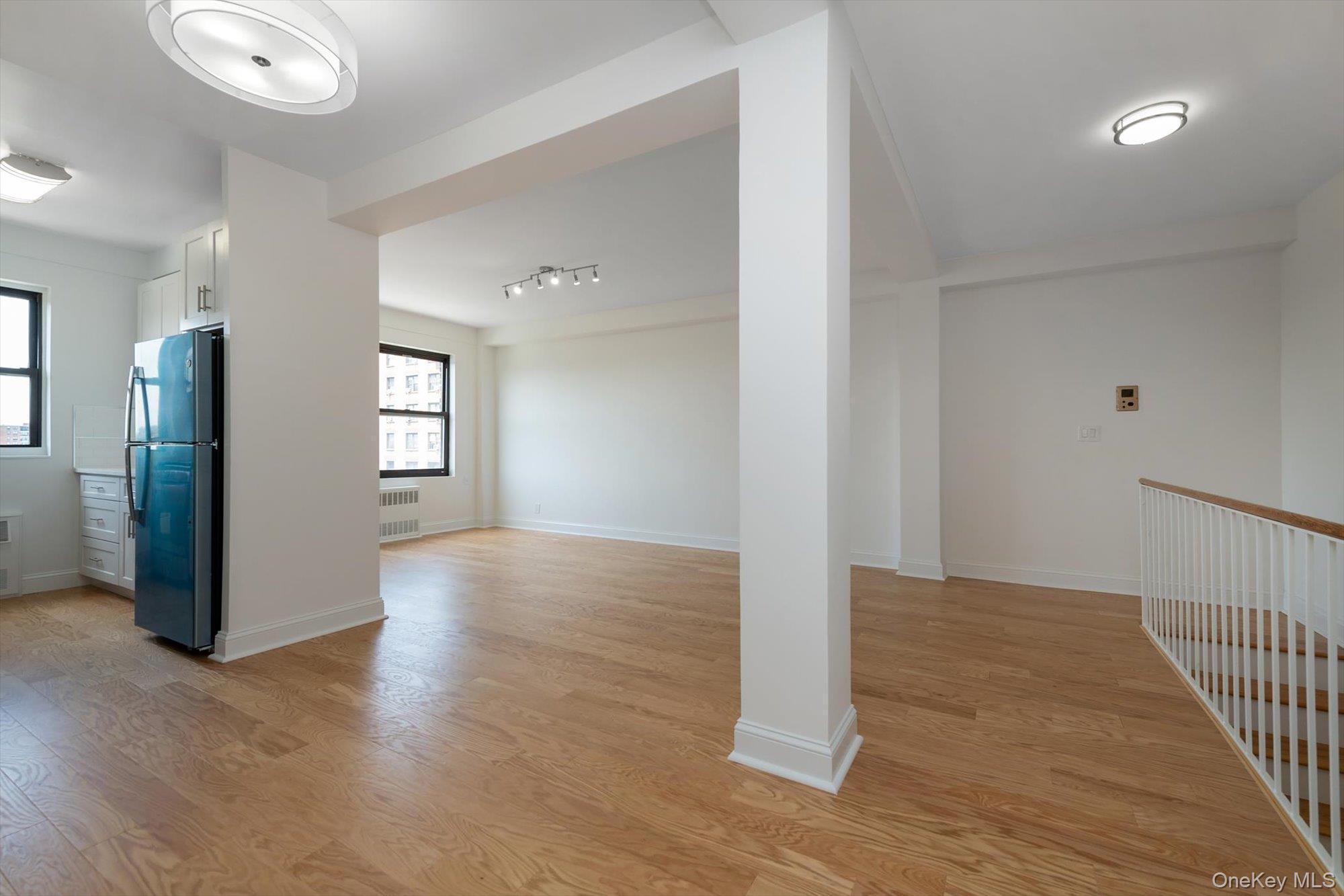 99-52 66th Road, Unit W7 Queens, NY 11374 - Photo 3 of 22 an empty room with wooden floor and windows
