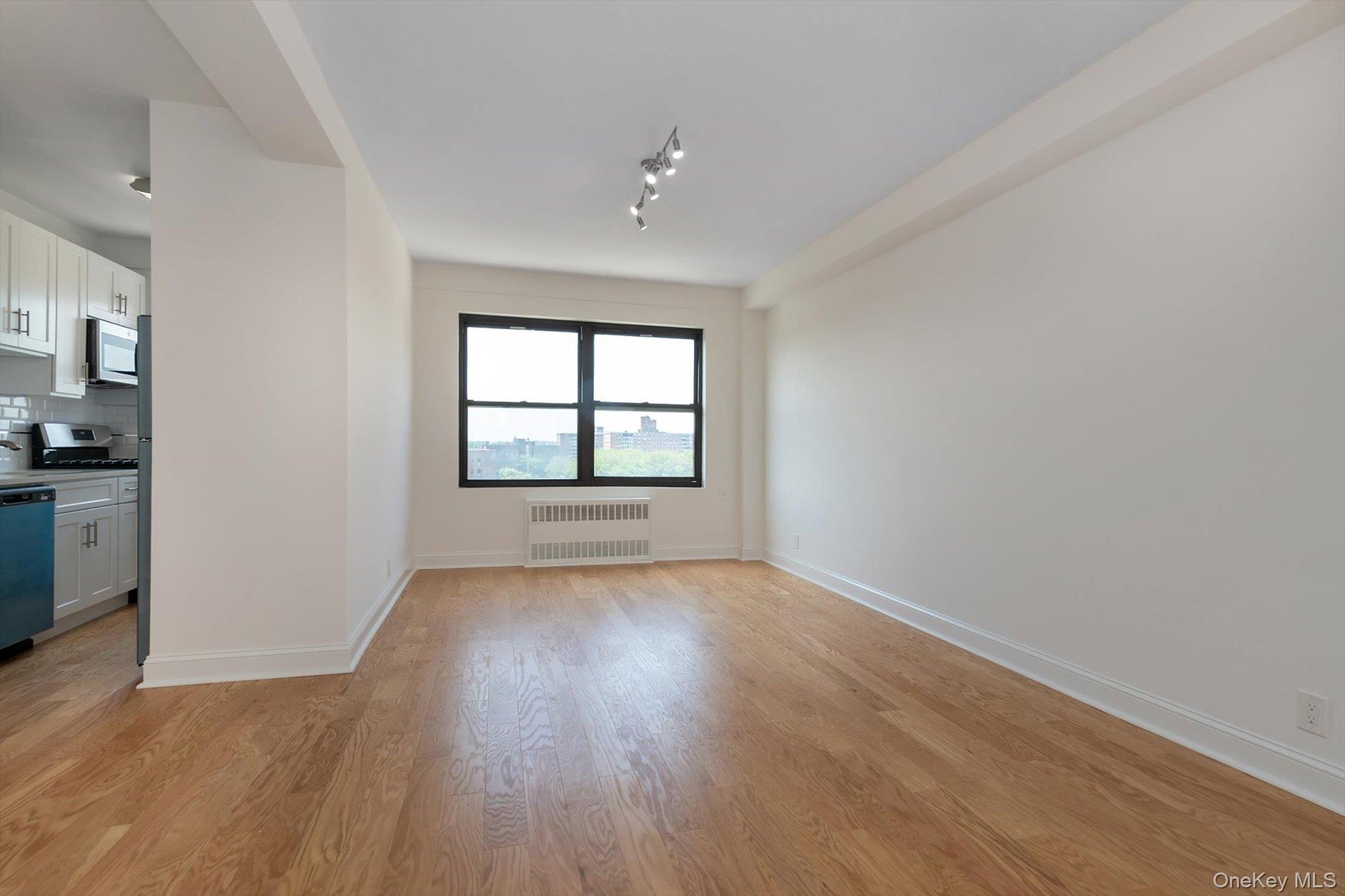 99-52 66th Road, Unit W7 Queens, NY 11374 - Photo 4 of 22 wooden floor in an empty room with a window