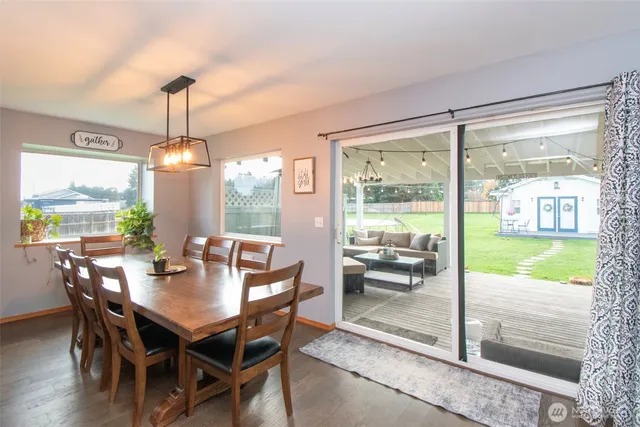 a dining room with furniture a chandelier and wooden floor