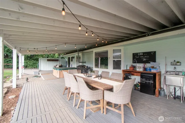 a view of a patio with table and chairs potted plants with wooden floor and fence