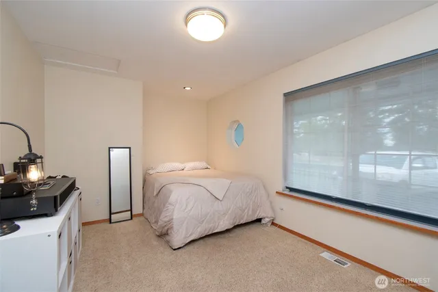 a bedroom with a bed and a large window