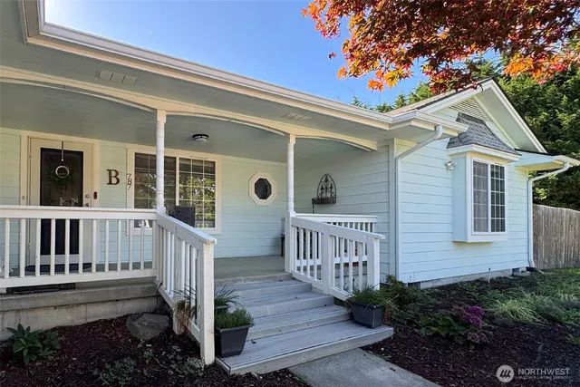 a view of a house with wooden fence and floor to ceiling window and wooden fence