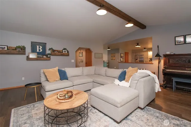 a living room with furniture a rug and kitchen view