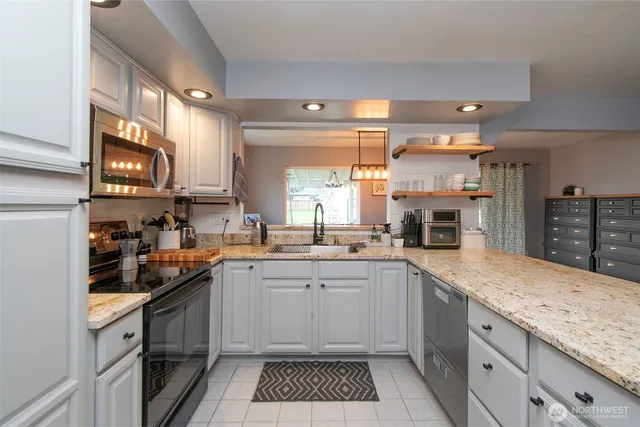 a kitchen with a sink stove top oven and cabinets