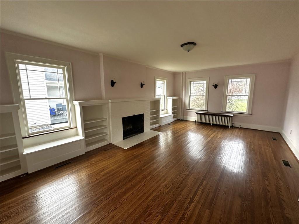 919 Oak Street Indiana, PA 15701 - Photo 5 of 27 an empty room with wooden floor a fireplace and windows