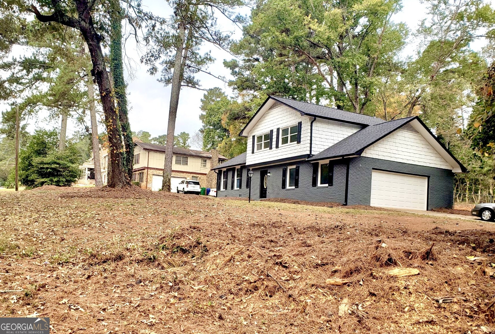 5058 Rock Springs Road Lithonia, GA 30038 - Photo 27 of 28 a front view of a house with a yard and large trees