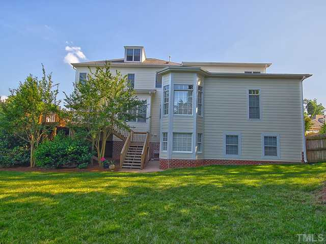 1812 Stannard Trail Raleigh, NC 27612 - Photo 23 of 25 Sit back and relax in your beautifully landscaped backyard. The stairs in the distance lead to the private deck. Notice how even the back of the home is filled with architectural details. Back Yard