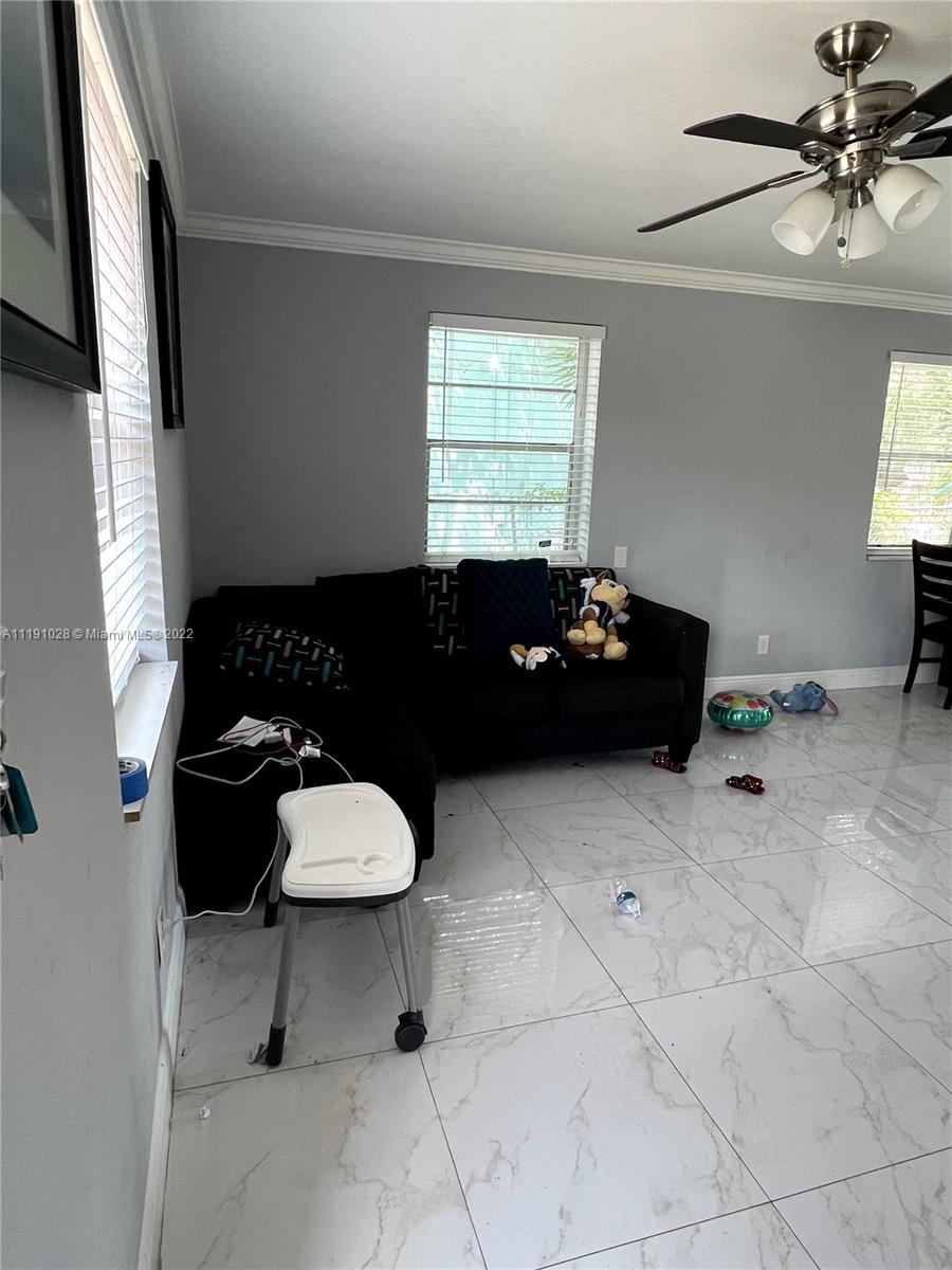 554 West 2nd Street Riviera Beach, FL 33404 - Photo 10 of 11 a living room with a black white checkered floor with a dining table and chairs