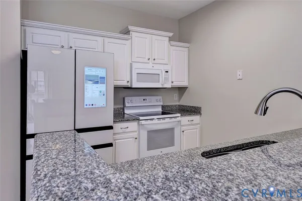 a kitchen with a stove a refrigerator and cabinets
