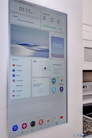 a kitchen with a sink dishwasher and white cabinets with wooden floor