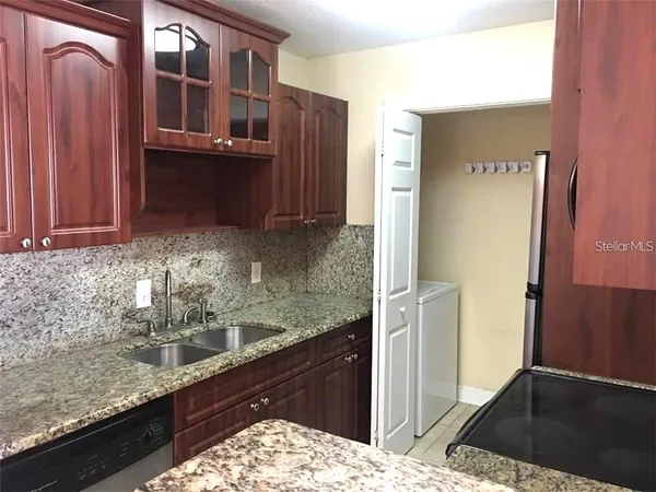 a kitchen with granite countertop a refrigerator and a sink