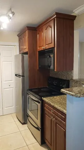 a kitchen with granite countertop a refrigerator stove and microwave