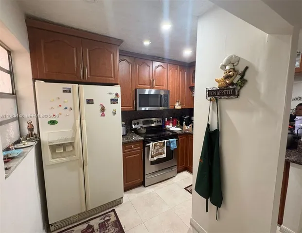 a kitchen with stainless steel appliances granite countertop a refrigerator and a stove top oven