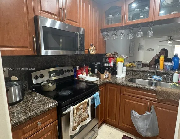 a kitchen with stainless steel appliances granite countertop a stove a sink and a microwave