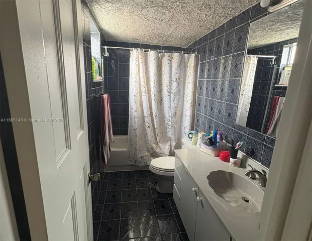 a bathroom with a double vanity sink toilet and shower