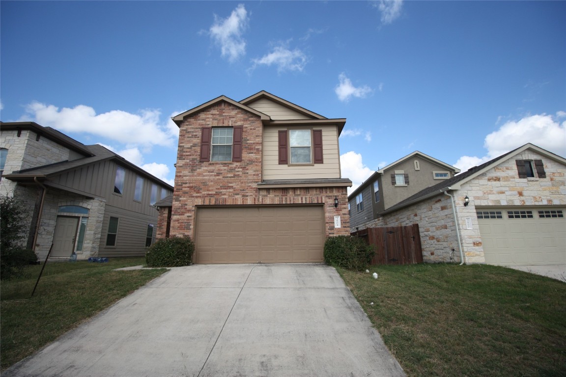 a front view of a house with a yard and garage
