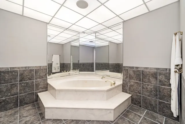 a bathroom with a tub a sink and window