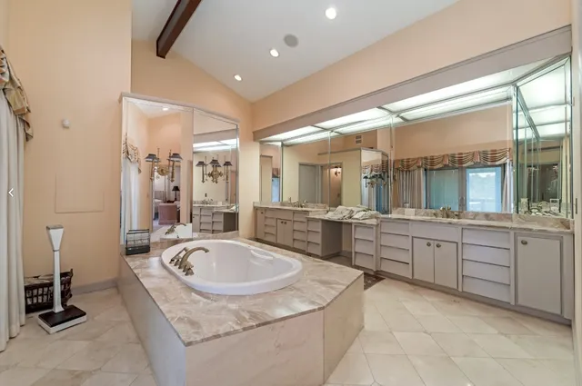 a large bathroom with a tub a sink a mirror and a shower