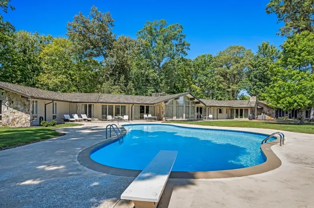 a view of a house with swimming pool and sitting area