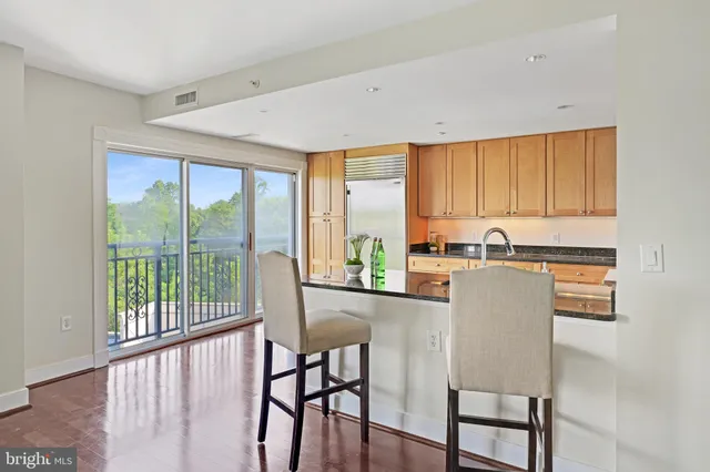 a kitchen with stainless steel appliances kitchen island wooden cabinets and a window