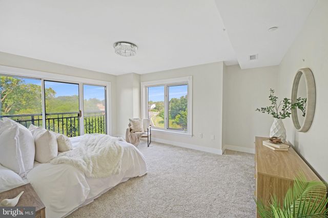 a living room with furniture a mirror and a potted plant