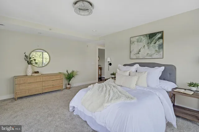 a living room with furniture a mirror and a potted plant