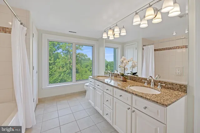 a bath room with a granite countertop sink and a mirror
