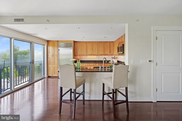 a open kitchen with granite countertop a refrigerator a sink and a large window