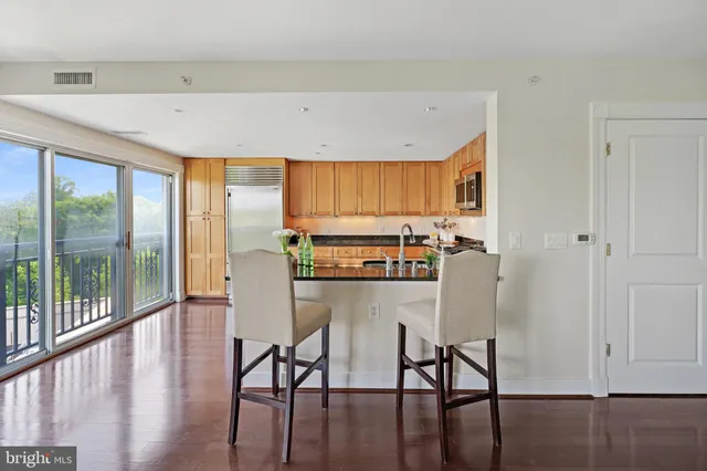 a kitchen with kitchen island granite countertop a sink and white cabinets