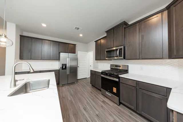 a kitchen with wooden cabinets and stainless steel appliances