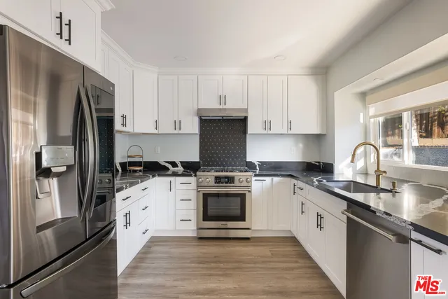 a kitchen with a stove a sink and a microwave