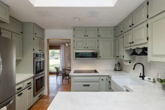 a kitchen that has a lot of cabinets in it and appliances
