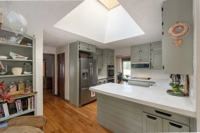 a kitchen with stainless steel appliances a stove cabinets and wooden floor