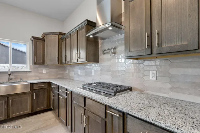 a kitchen with stainless steel appliances granite countertop a sink stove and cabinets