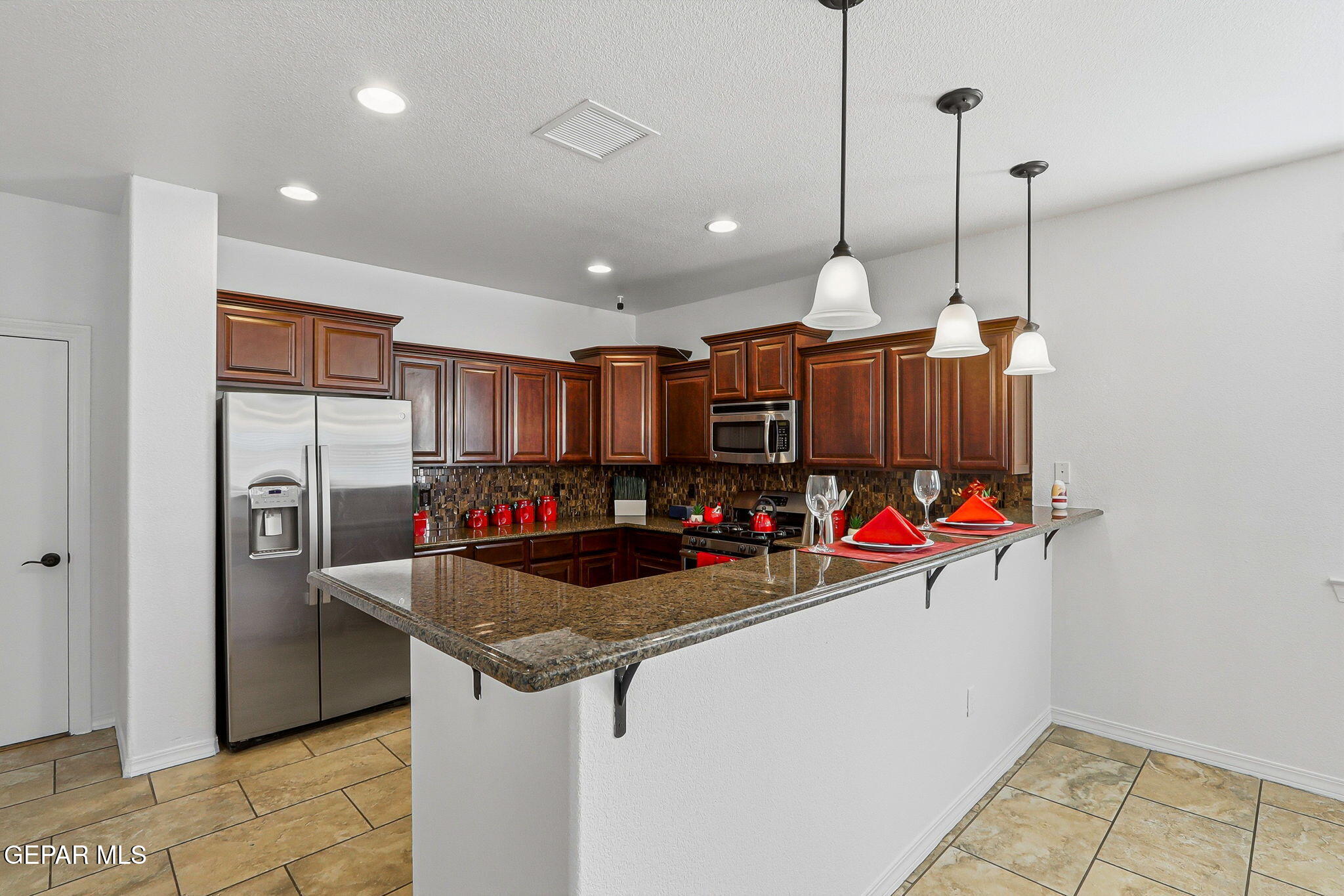520 Gomez Road El Paso, TX 79932 - Photo 22 of 72 a kitchen filled with stainless steel appliances granite countertop a sink a refrigerator and a wooden cabinets