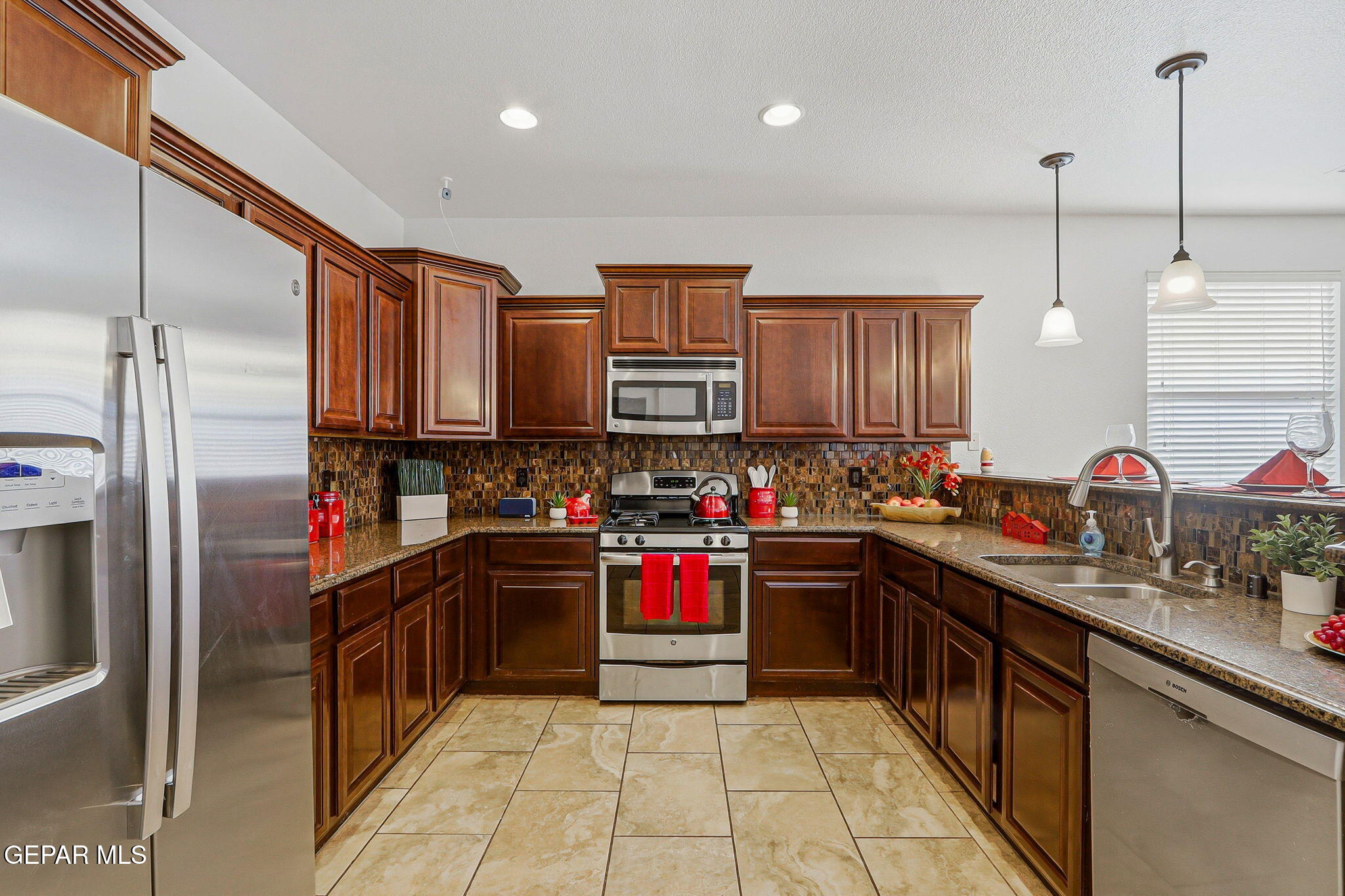 520 Gomez Road El Paso, TX 79932 - Photo 24 of 72 a kitchen with stainless steel appliances granite countertop a refrigerator and a sink