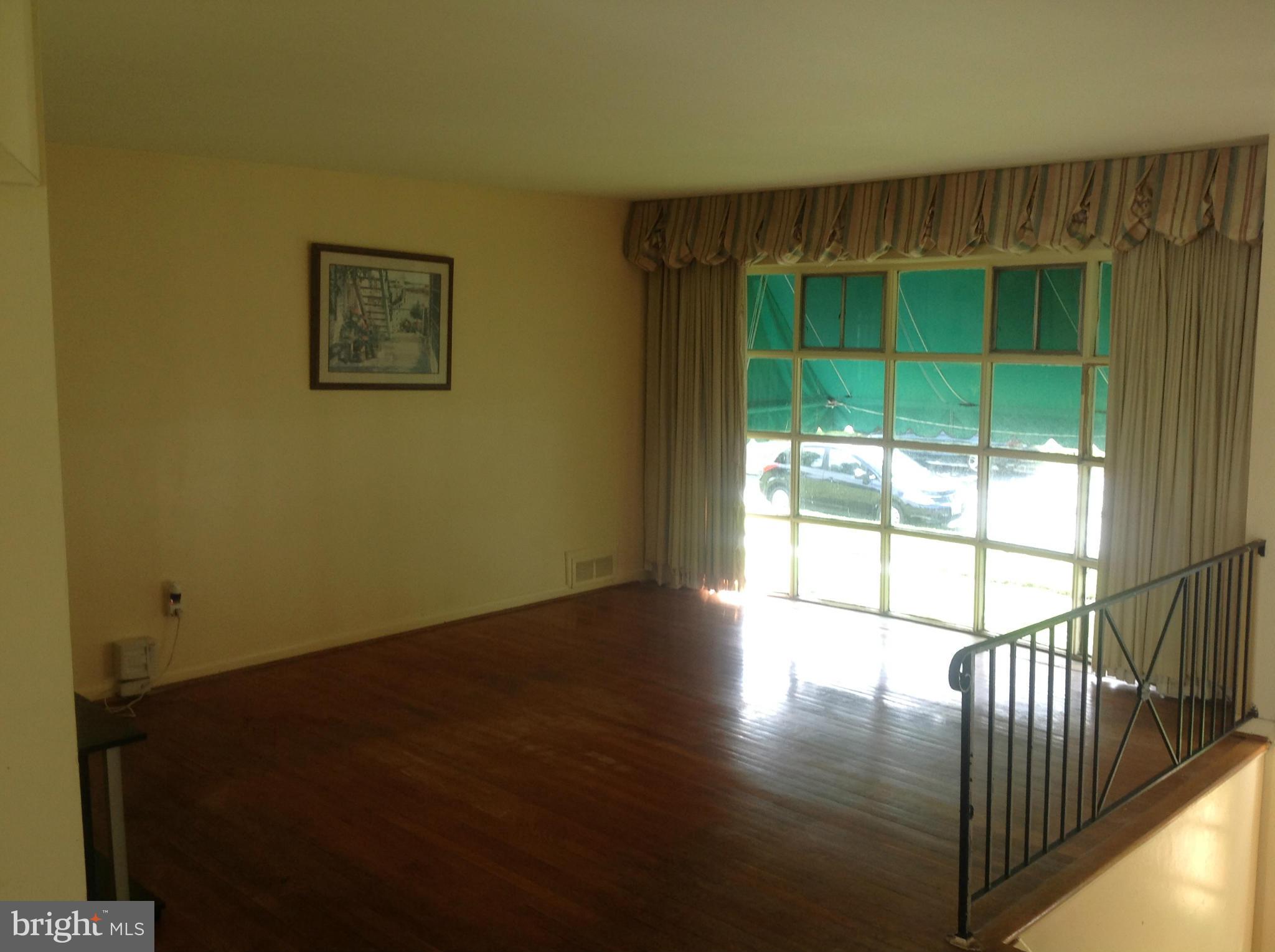 12701 Barbara Road Silver Spring, MD 20906 - Photo 6 of 21 a view of an empty room with wooden floor and a window
