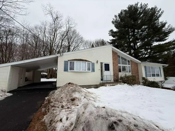 a front view of a house with a yard covered in snow
