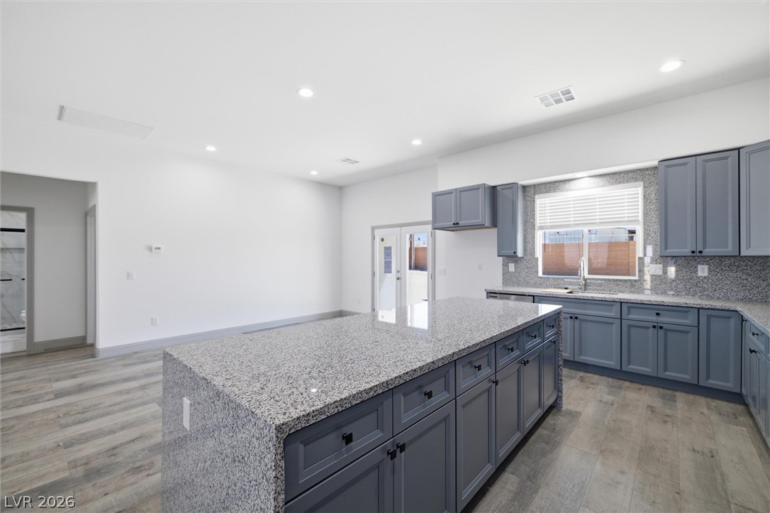 1061 Factory Road Pahrump, NV 89048 - Photo 16 of 41 A spacious kitchen with sleek gray cabinetry and polished granite countertops creates a welcoming atmosphere.