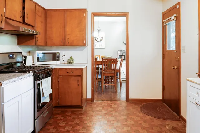 a kitchen with stainless steel appliances granite countertop a refrigerator a stove and a sink with large cabinets