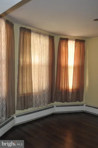 an empty room with wooden floor and door