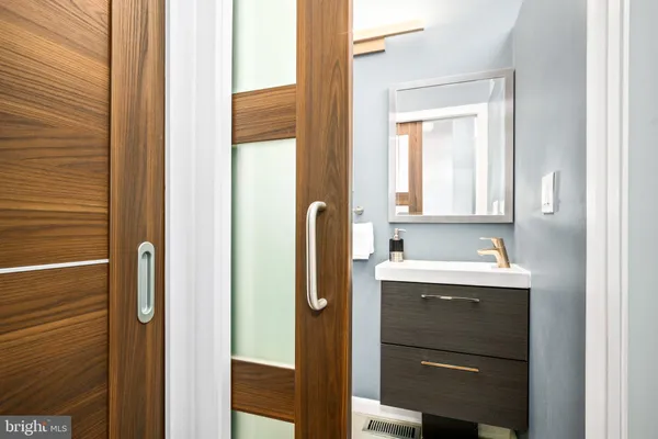 a bathroom with a sink vanity and mirror