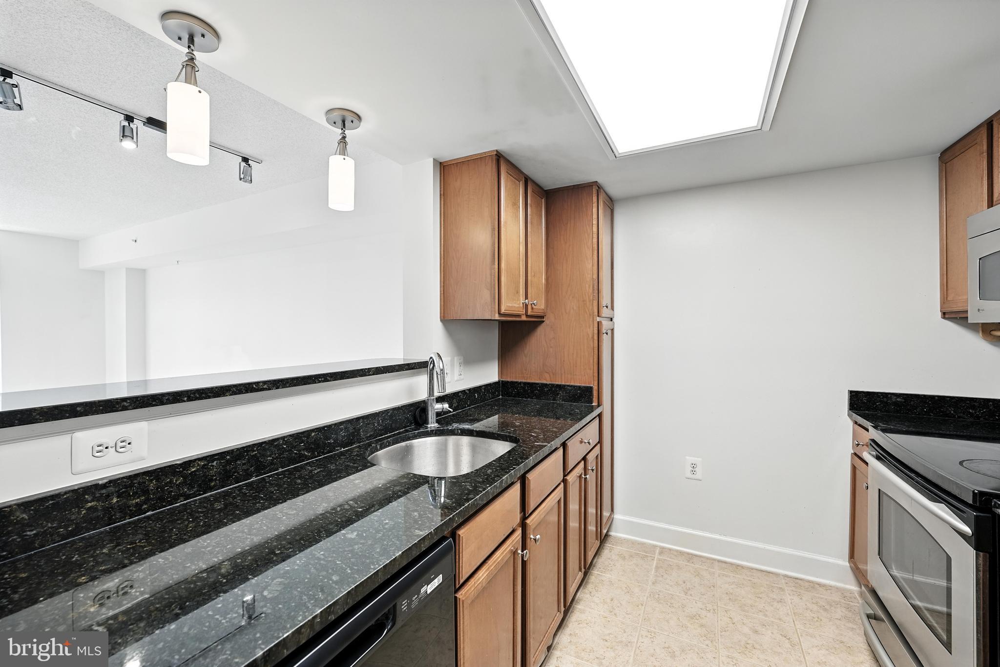 11800 Sunset Hills Road, Unit 818 Reston, VA 20190 - Photo 5 of 26 a kitchen with granite countertop a sink and a stove top oven
