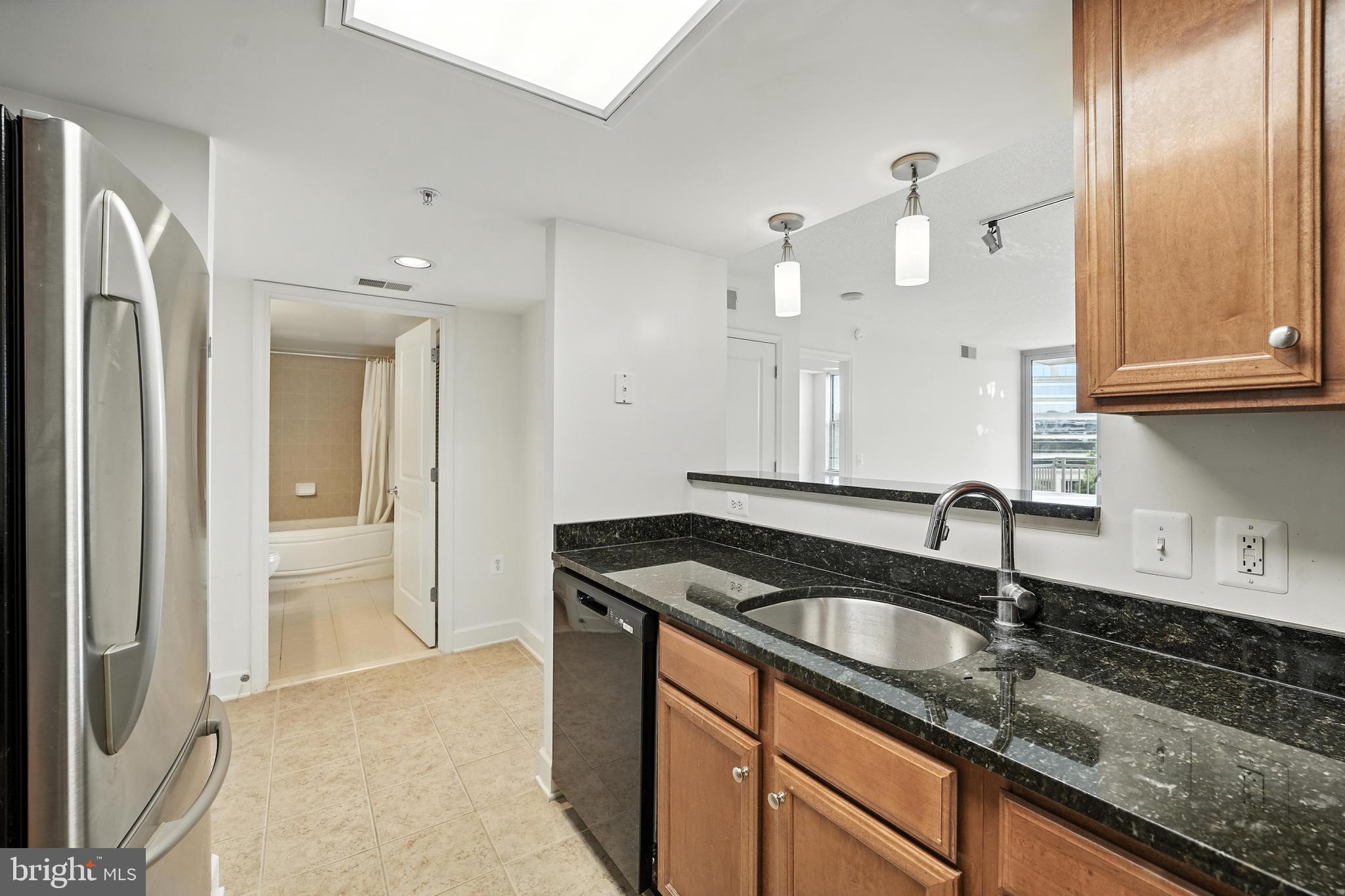 11800 Sunset Hills Road, Unit 818 Reston, VA 20190 - Photo 7 of 26 a kitchen with granite countertop a sink and cabinets