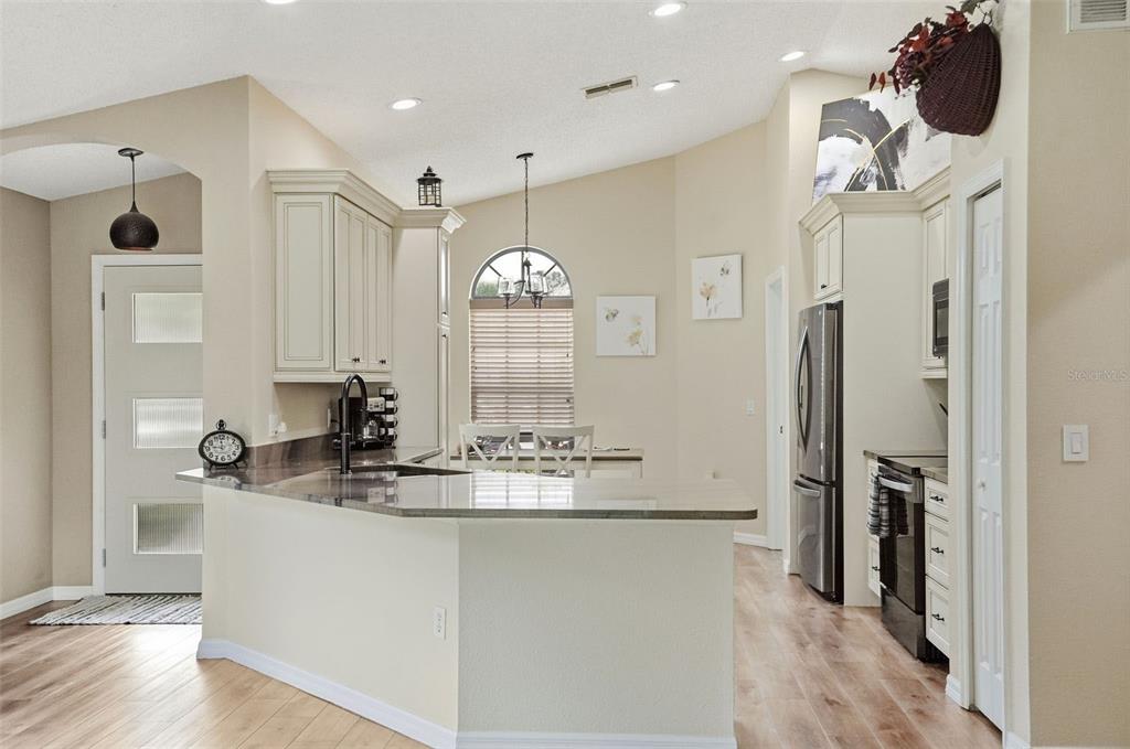 11437 Deercroft Court Spring Hill, FL 34609 - Photo 12 of 37 a kitchen with a refrigerator a sink and a table