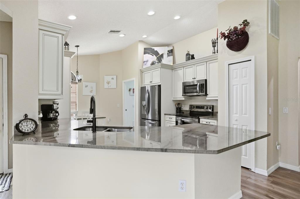 11437 Deercroft Court Spring Hill, FL 34609 - Photo 13 of 37 a kitchen with stainless steel appliances granite countertop a sink and a refrigerator