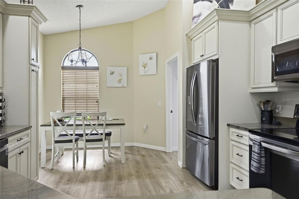 11437 Deercroft Court Spring Hill, FL 34609 - Photo 14 of 37 a kitchen with stainless steel appliances a dining table chairs stove refrigerator and cabinets